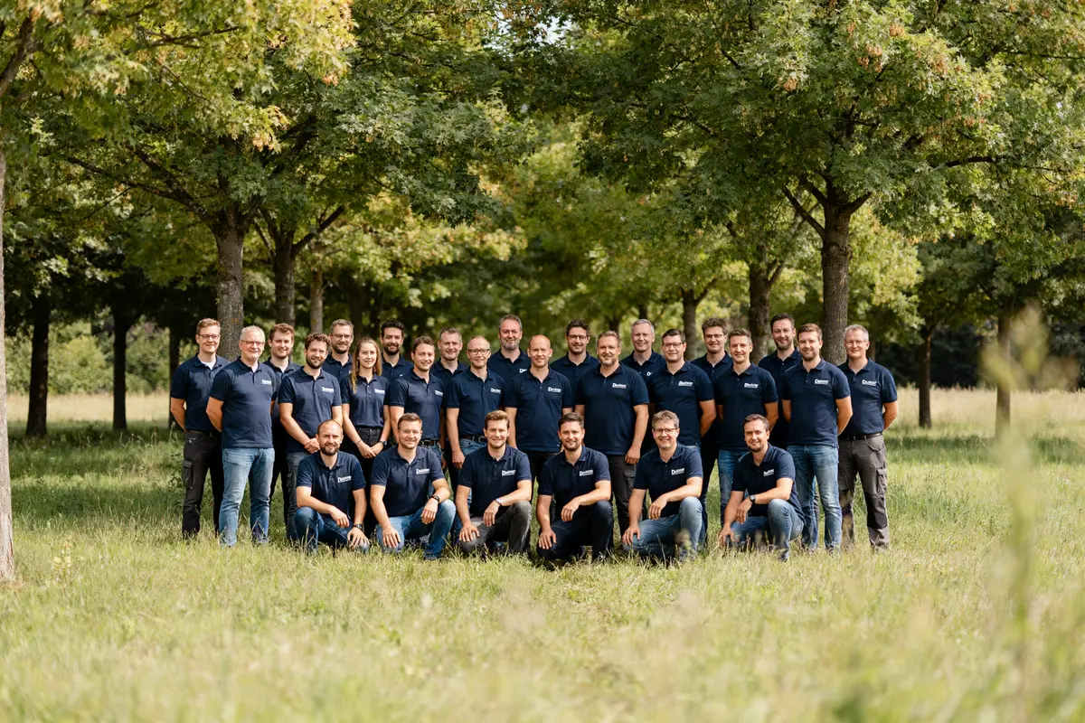 Groupe de salariés de Dachser Strasbourg posant dans un parc verdoyant.