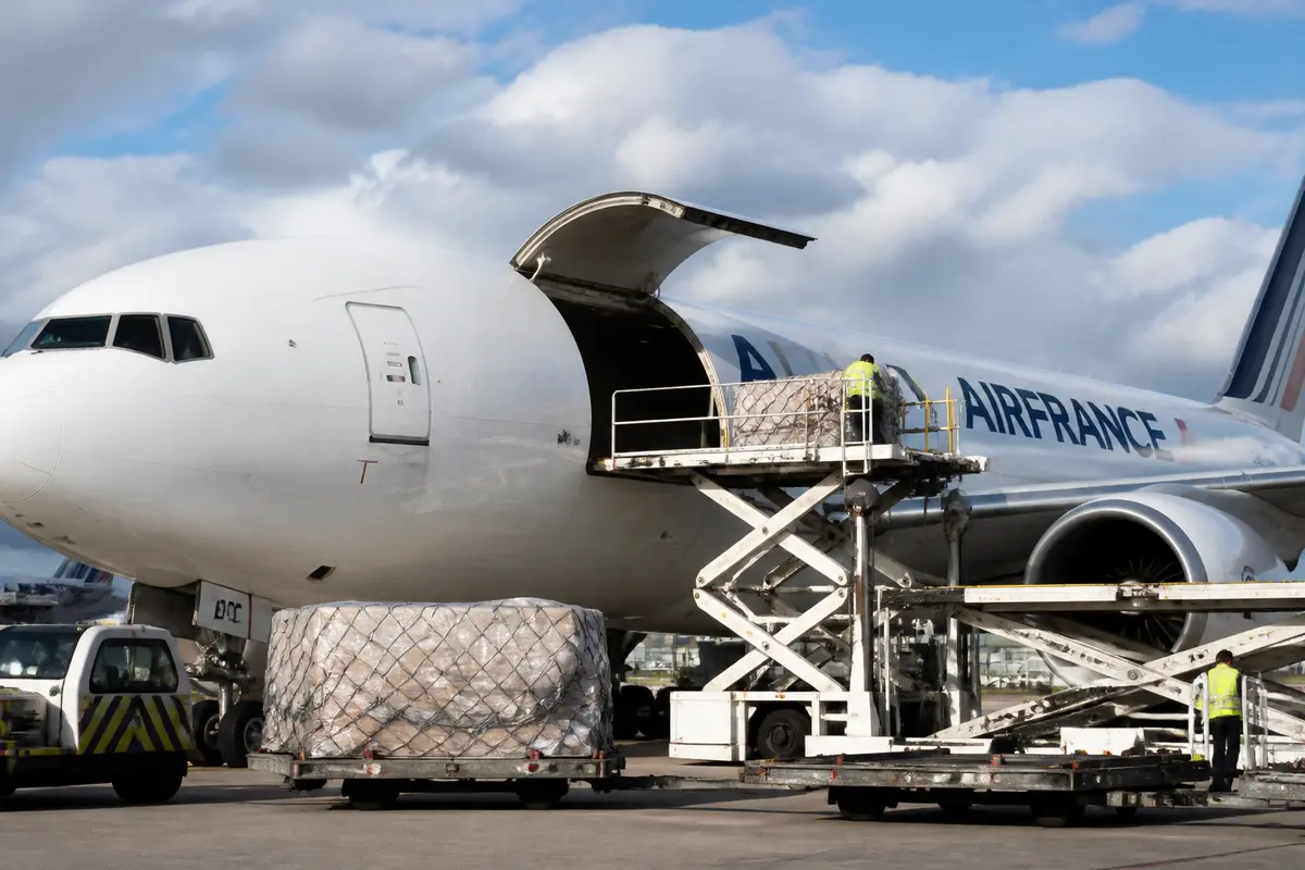 Chargement d'un avion de fret Air France Cargo à l'aéroport avec palettes de marchandises