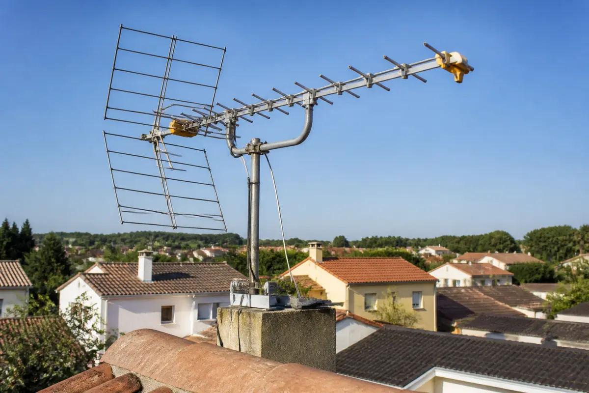 Antenne râteau sur toit, captant les signaux pour L'Antenne, ciel bleu en arrière-plan