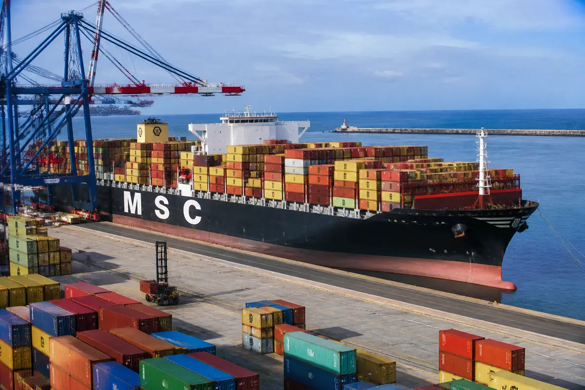 Navire de fret MSC chargé de conteneurs colorés au port industriel.