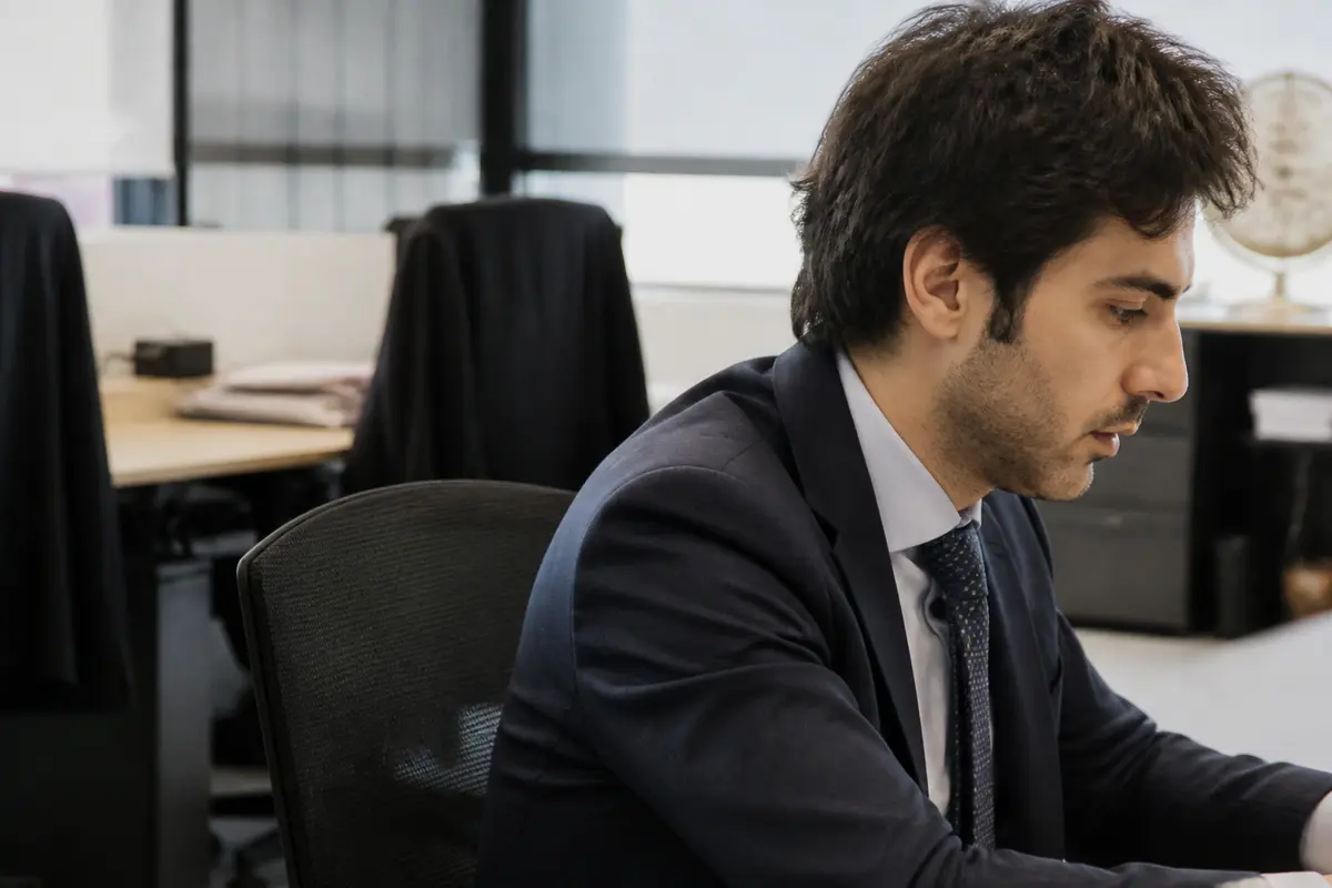 Un homme en costume travaille dans un bureau moderne chez Mitsiu