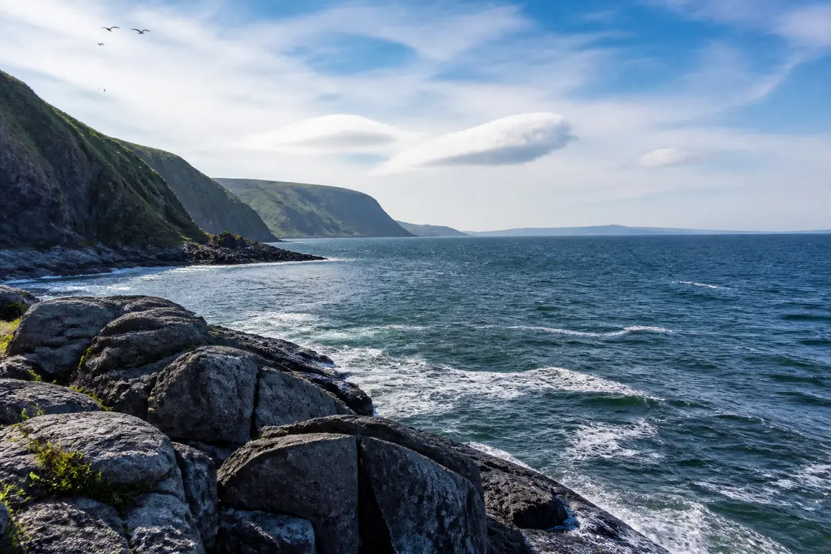 Côte rocheuse et mer bleue sous ciel dégagé près de Okhotsk en Russie