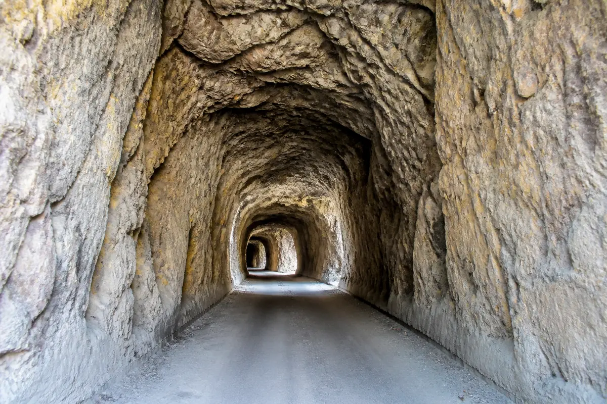 Intérieur rocheux du tunnel du col de Tende avec lumière naturelle à l'entrée