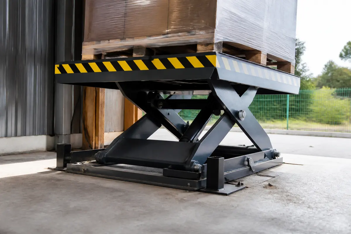Palette posée sur tables élévatrices en métal pour levage industriel efficace et sécurisé